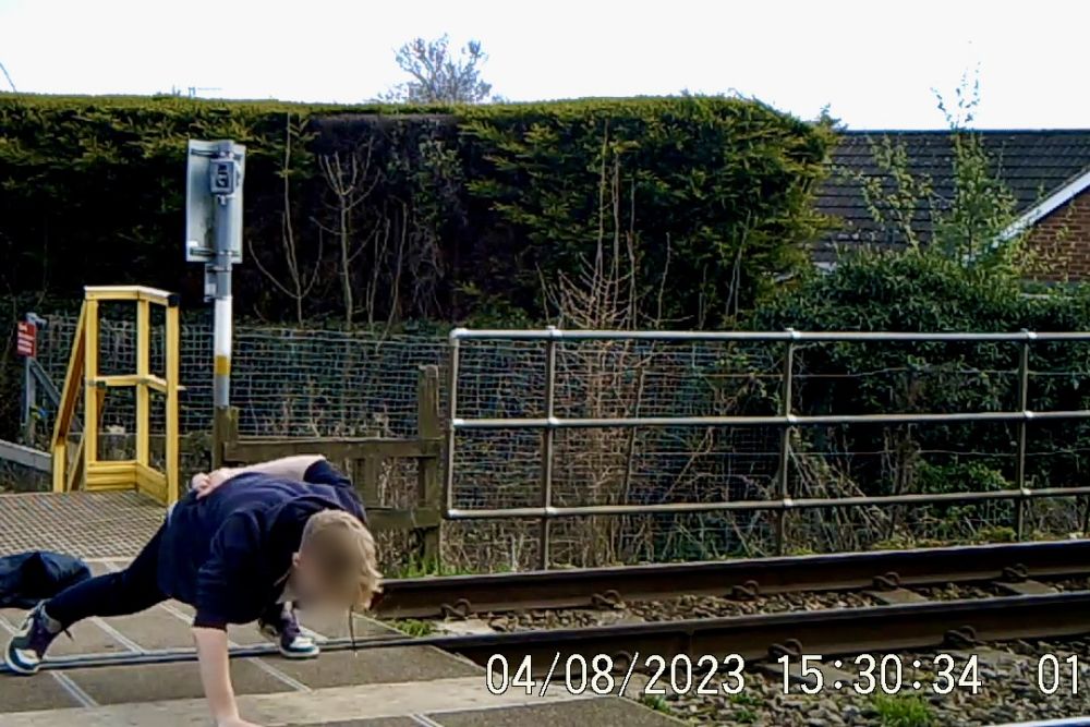 loud music playing while a teenager does one-armed press ups in the middle of a crossing © Network Rail
